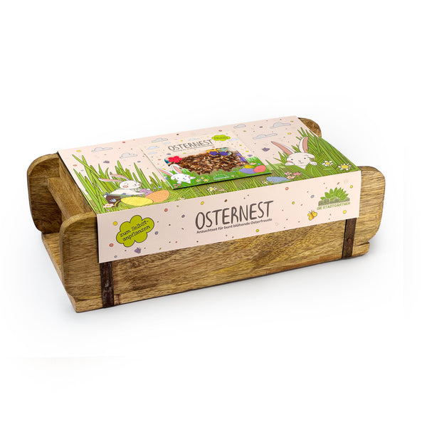 Cuenco de madera con decoración y embalaje de Pascua, etiquetado "Nido de Pascua" y motivos de conejitos.