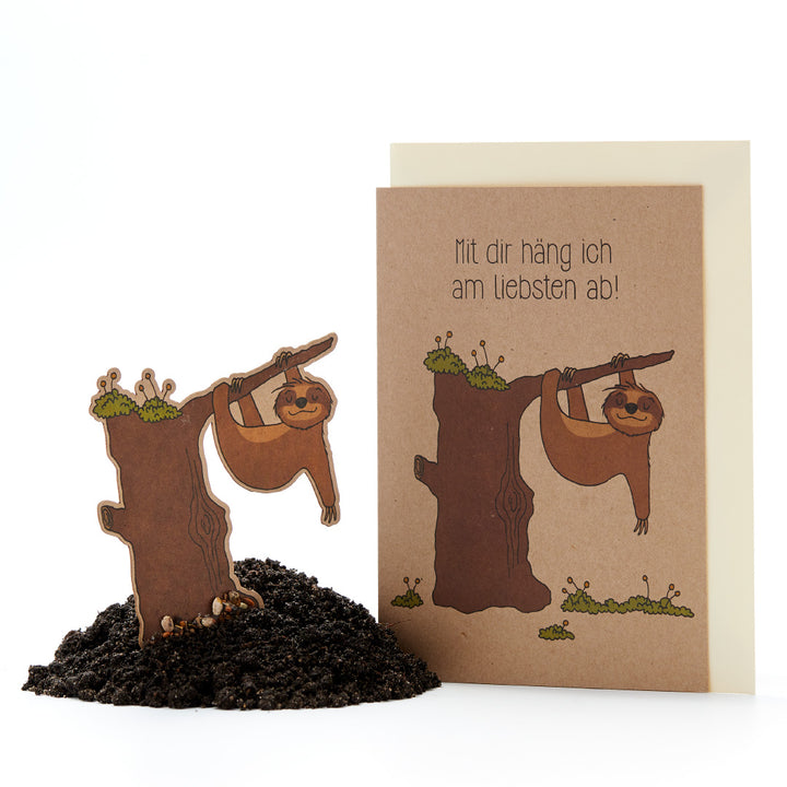 Divertida tarjeta de felicitación con figuras de perezosos colgando del tronco de un árbol, texto: "¡Me encanta pasar el rato contigo!"