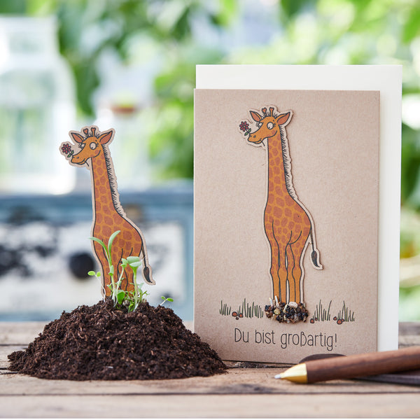 Tarjeta de felicitación con motivo de jirafa y las palabras "¡Eres increíble!" junto a un montón de tierra y un lápiz.