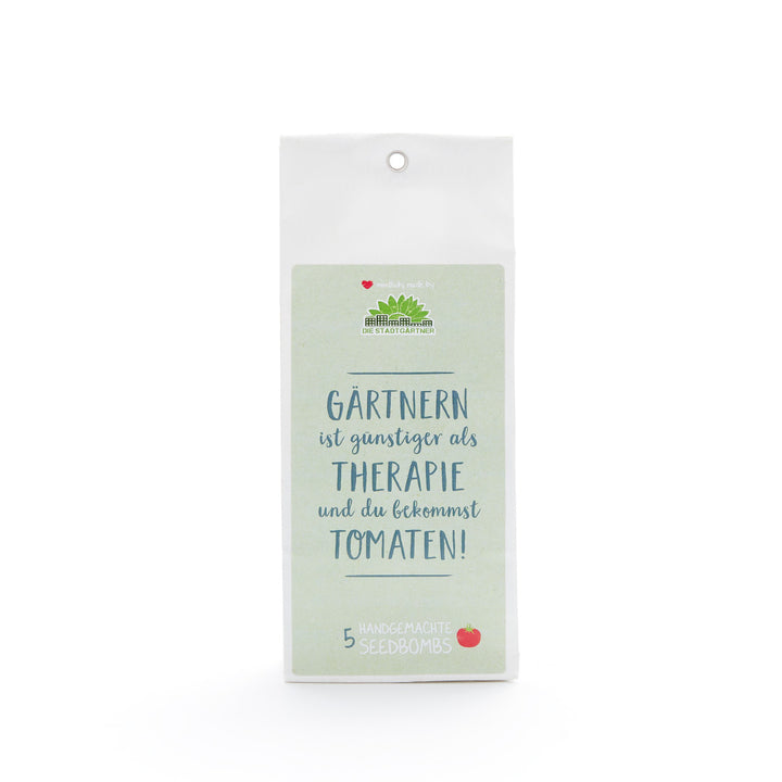 Embalaje para bombas de semillas hechas a mano con el texto "¡La jardinería es más barata que la terapia y obtienes tomates!" en alemán.