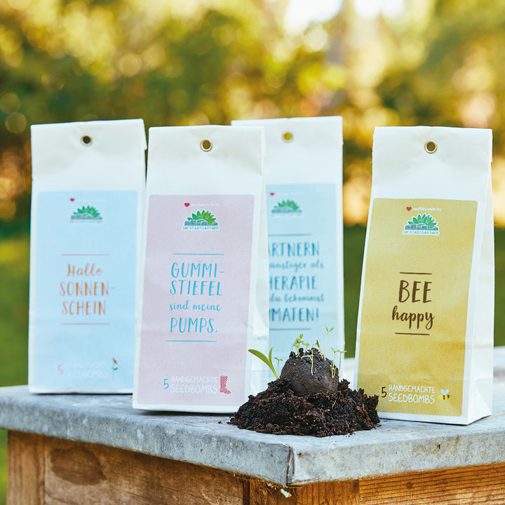Bombas de semillas empaquetadas con refranes divertidos sobre una base de piedra en el jardín.