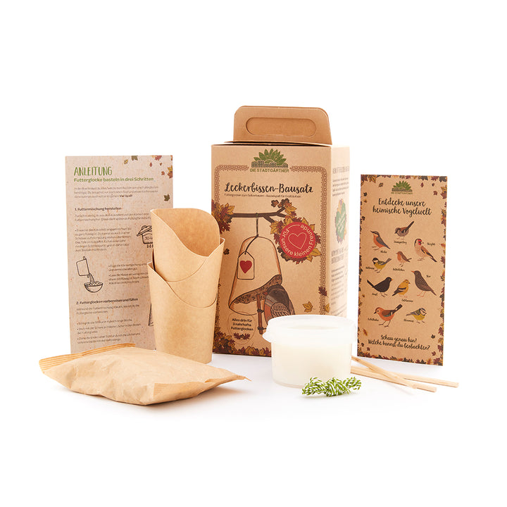 Kit de comedero para pájaros con instrucciones y suministros sobre un fondo blanco.