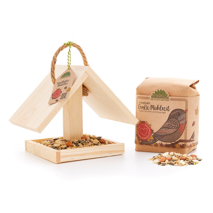 Comedero para pájaros con comida para pájaros como idea de regalo.