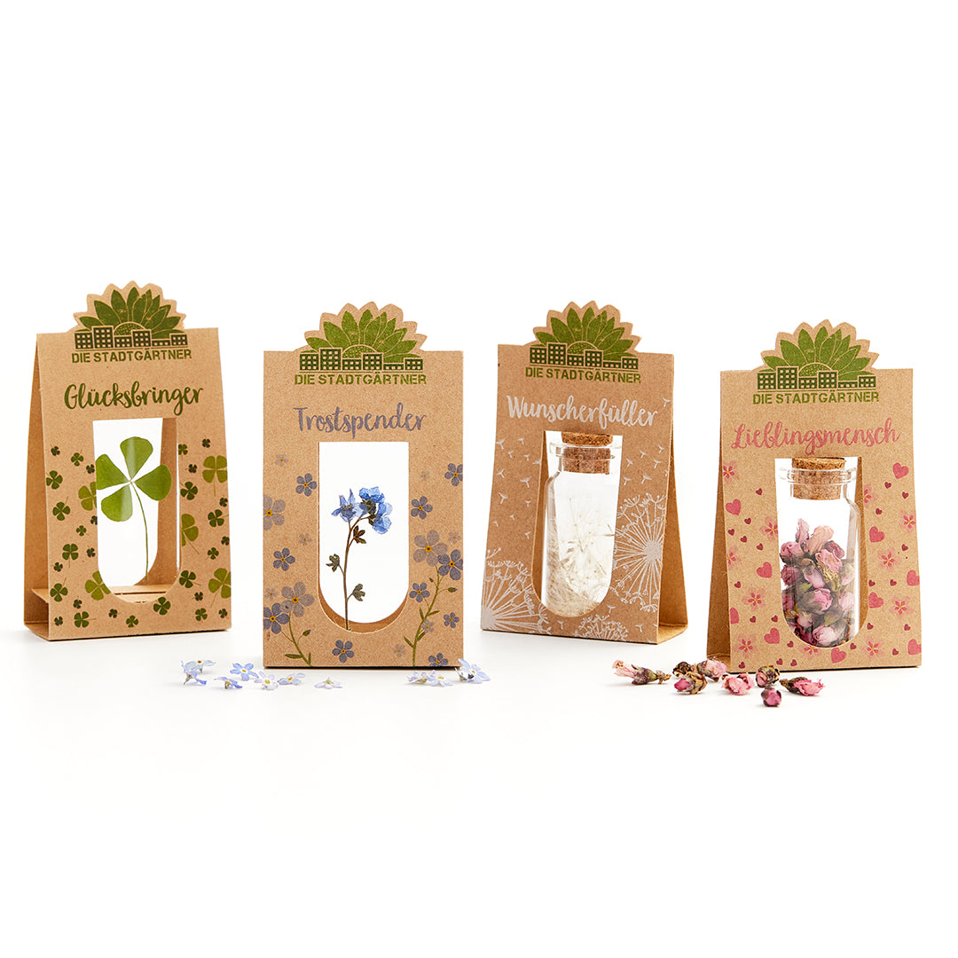 Cuatro bolsas de regalo con motivos naturales y etiquetas: Amuleto de la suerte, Consolador, Cumplidor de deseos, Persona favorita.